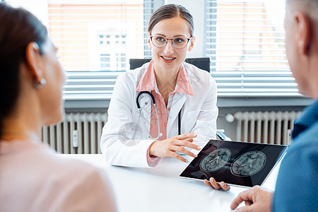 在平板电脑上向病人展示X光照片的女医生专家办公室桌子卫生全科手术夫妻保健工作药品图片