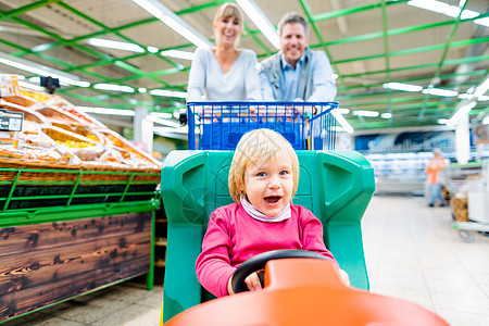 在超市用特别儿童车在小儿车买夫妻妈妈杂货店走道购物车大车水果货架快乐乐趣购物图片