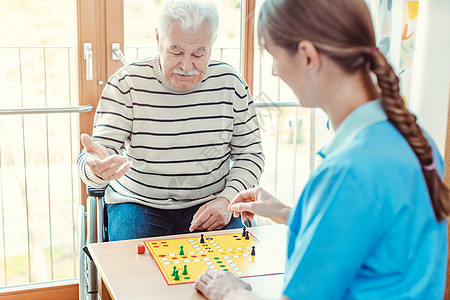 退休养老院的护士和高级年长者玩棋盘游戏残障服务活动疗养院男人护理祖父老年人团体老人图片