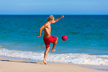 在海滩上玩足球的人运动天空活动海洋晴天闲暇训练诡计锻炼男人图片