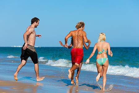 朋友在沙滩度假情侣团体海洋假期朋友们闲暇跑步娱乐蓝色阳光照射图片