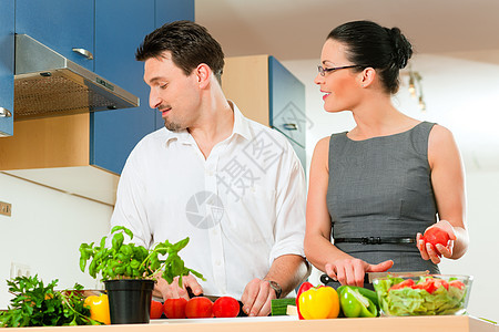 夫妻在厨房一起煮饭女孩丈夫乐趣妻子平底锅微笑蔬菜草药裙子男人图片