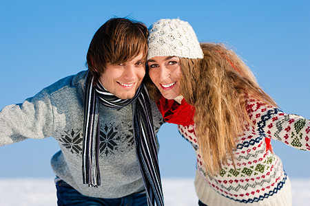 夫妇在冬天散步拥抱浪漫蓝色套衫闲暇男人微笑成人女士天空图片