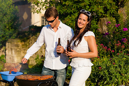 夏天在花园里做BBQ的情侣食物女士炙烤朋友享受男人香肠烧烤啤酒闲暇图片