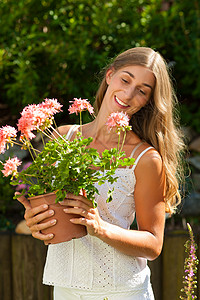夏天的花园     带鲜花的快乐女人花店园丁花朵白色乡村阳台植物裙子爱好寄养图片
