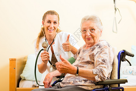 年轻护士和在养老院的女老人帮助福利照顾者公益女性轮椅服务员护理病人测量图片