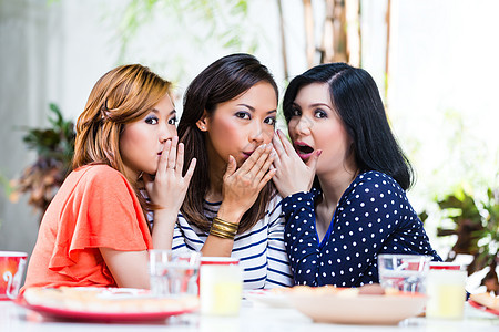 亚裔女性在闲谈八卦闲暇姐姐姐妹秘密餐具谣言桌子热带女朋友图片