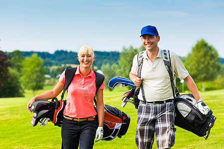 年轻运动夫妇在赛场打高尔夫球玩家活力竞赛娱乐闲暇爱好夫妻男人乐趣女士图片