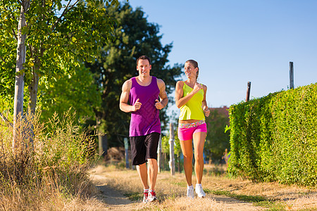 男人和女人竞跑运动力量乡村泥路慢跑者自信运动员夫妻耐力麦田场地图片