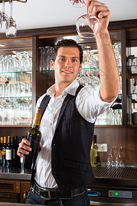 酒吧后面的酒后男士男人酒杯酒店酒精眼镜白酒微笑乐趣玻璃酒窖图片
