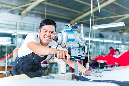 亚洲工人在工厂里使用一台机器领班安全控制制造业工作导师刀具服装手套职业图片