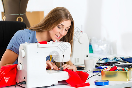 在工作室工作的时装设计师或裁缝剪裁设计自由职业者乐趣女裁缝织物店铺喜悦女士女性图片