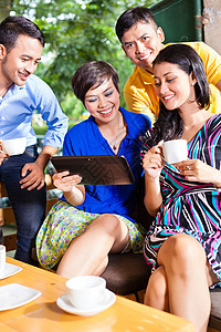 亚洲咖啡厅的青年群体 青年人组咖啡店空闲乐趣女性同事杯子讲话平板电子邮件药片图片