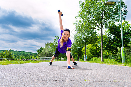 户外运动     在公园健身的年轻妇女平衡绿地运动员哑铃体操跑步训练女士力量女孩图片