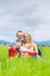 家庭快乐户外 坐在草地上父母父亲兄弟姐妹女孩童年女士孩子们妈妈姐姐乐趣图片