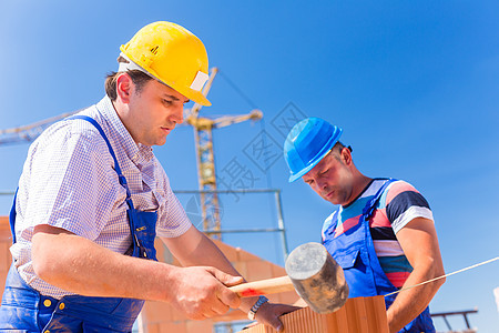 建筑工地工人在房屋上筑墙壁安全帽工作房地产就业男性建设者工匠脚手架砖块起重机图片