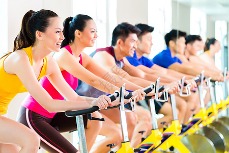 亚洲人在健身体育馆操动自行车训练重量挑战中心女性脉冲衣服男人班级耐力运动图片