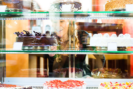 从面包店挑选蛋糕的客人水果女士微笑玻璃女性糖果甜点咖啡柜台展示图片