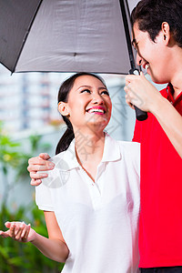 亚洲情侣在雨雨中带着雨伞走来走去图片