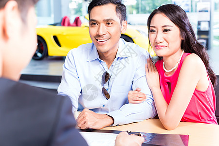 亚洲夫妇签署经销商汽车销售合同的亚洲夫妇保险女士交易推销员夫妻男人办公室协议融资客户图片