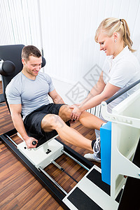 在体育治疗中进行运动治疗的生理治疗者疗法病人机器男人脊椎紧张硬化工作治疗师肌肉图片