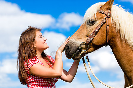 女人在小马农场上宠物马匹闲暇马术国家女孩关爱活动动物享受晴天乐趣图片