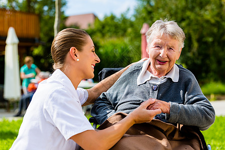 护士与坐在轮椅上的高级妇女握手的护士诊所医院医学病人残障老年护理花园养老院人士图片