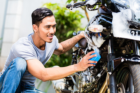 亚洲人洗摩托或骑摩托车的亚裔男子男人打扫发动机工作花园泡沫热带运输肥皂自行车图片