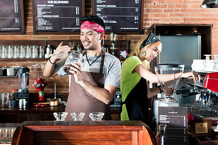 准备咖啡的亚洲咖啡厅中的男女咖啡机拿铁夫妻咖啡馆女士机器饮料酒吧职业酒保图片