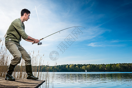 渔夫在湖边钓鱼垂钓者爱好牵引闲暇男人运动娱乐码头钓竿图片