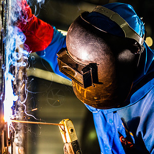 在工业工厂工作的焊接工建造工人面具场所生产作坊火花工具劳动员工图片