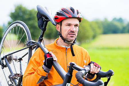 骑着自行车肩扛着自行车的赛车员图片