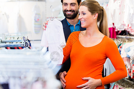 在商店买婴儿服装的孕妇和男男女妈妈零售衣服母亲店铺补给品用品怀孕女孩家庭图片