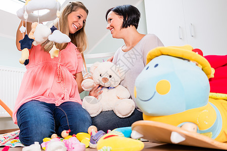 孕妇及其朋友为婴儿准备育婴幼儿的托儿所母亲房子怀孕房间玩具女性腹部苗圃儿童教养图片