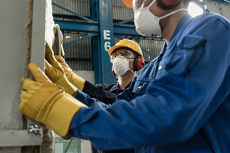 两名身着防护装备的蓝领工人制造业劳动者男人就业耳套安全职业安全帽手套材料图片