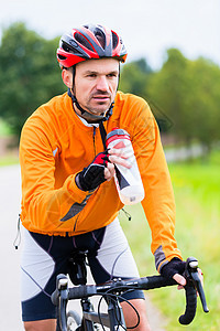 赛车自行车骑脚踏上自行车轨道的Cyclist运动踏板活动训练车轮运动员旅行运动服紧身衣男人图片