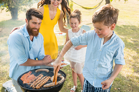 父亲和儿子在野餐时用烤烤烤烤肉烧烤炉做肉图片