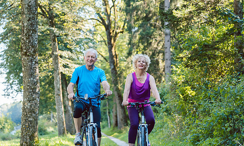 快乐和活跃的老年夫妇在公园户外骑单车小路骑术夫妻服装自行车爱好活力男人运动微笑图片