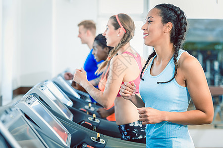 一个健康幸福女人的侧面观 以及她的运动车训练组男性健身房锻炼有氧运动跑步女士心血管自行车马尾辫高强度图片