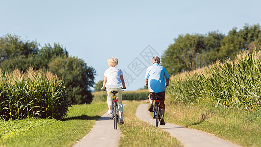 老年夫妇在骑自行车时满怀信心地期待向前看图片