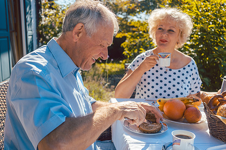 老年男女在花园里吃早饭的年长男女食物夫妻晴天男人女士早餐丈夫妻子桌子篮子图片