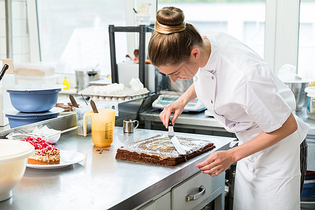 收信人女人拿巧克力蛋糕来准备托普糕点师质量面包师蛋糕烘烤甜点配料职业传统糖果图片