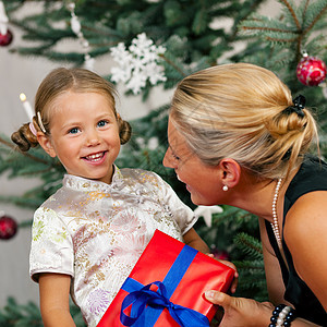 圣诞节     接受礼物的儿童父母妈妈母亲圣诞礼物孩子微笑女儿展示金发图片