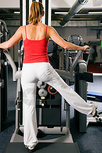 在健身房工作的妇女机器训练娱乐健身反抗闲暇数字举重重量肌肉图片