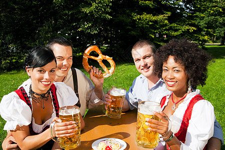 一群四人朋友在啤酒花园吃喝喝酒图片