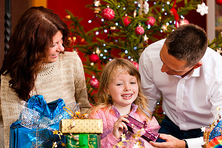 圣诞节  圣诞夜有礼物的家庭父母女孩母亲妈妈女儿喜悦幸福爸爸夫妻惊喜背景图片