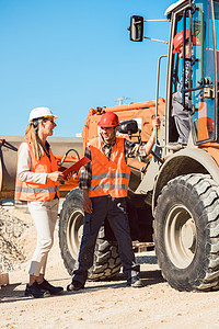 关于道路建设工地的土木工程师和工人讨论职业工程施工笔记挖掘土方橙子标志商业女士图片