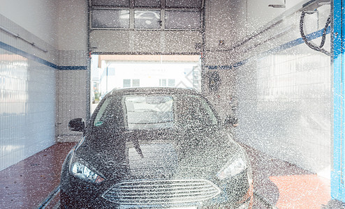 在洗车时将泡沫装上汽车商业服务刷子肥皂洗涤剂洗涤自助图片
