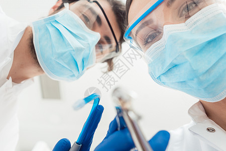 从角度看有趣的牙医和他们的工具助手牙科风镜房间男人面具手术办公室护目镜女士图片
