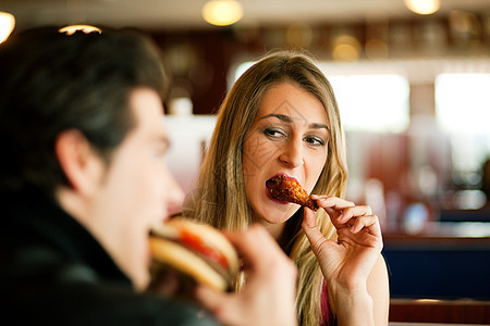 餐厅的一对夫妇吃快餐男人食物汉堡乐趣享受朋友们成人夫妻晚餐浪漫图片